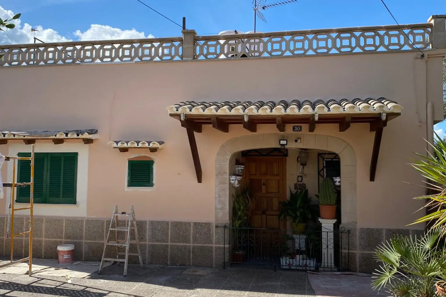 La misma fachada mallorquina ya saneada y pintada, con el friso original respetado